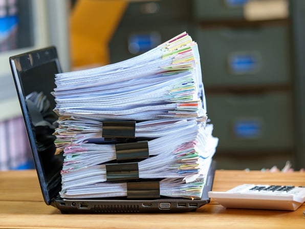 stack of paper on laptop